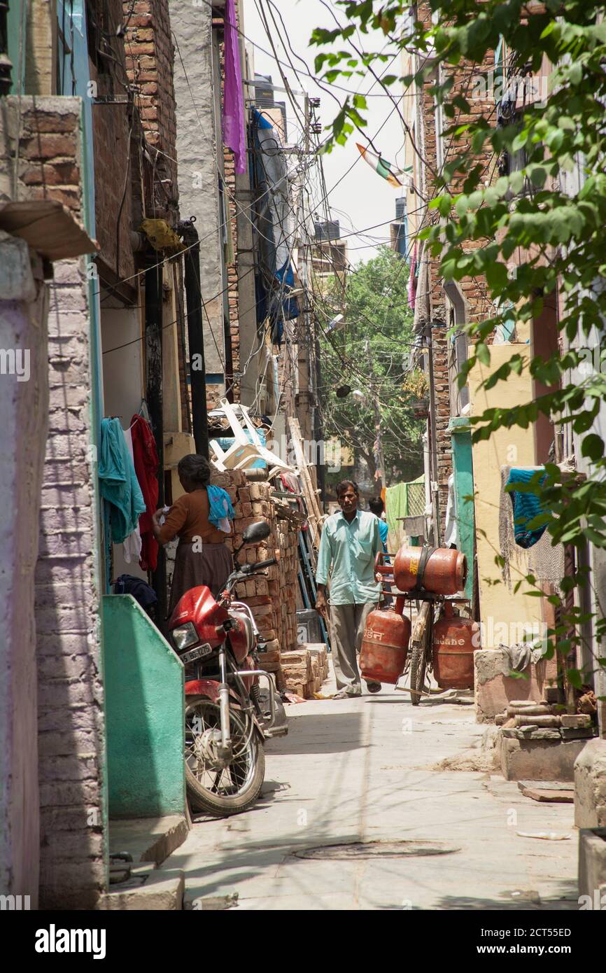 Un hombre en un callejón abarrotado en los barrios bajos de Delhi, India Foto de stock