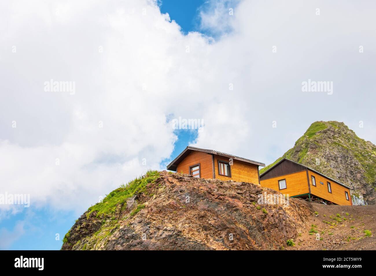 Dos casas de madera en la cima de una montaña. Mira a la cordillera con  nubes y cielo Fotografía de stock - Alamy