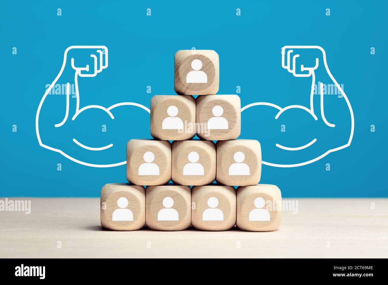 Bloques de madera apilados como pirámide de jerarquía con iconos de personas. Poder de trabajo en equipo, solidaridad o cooperación en concepto empresarial. Foto de stock
