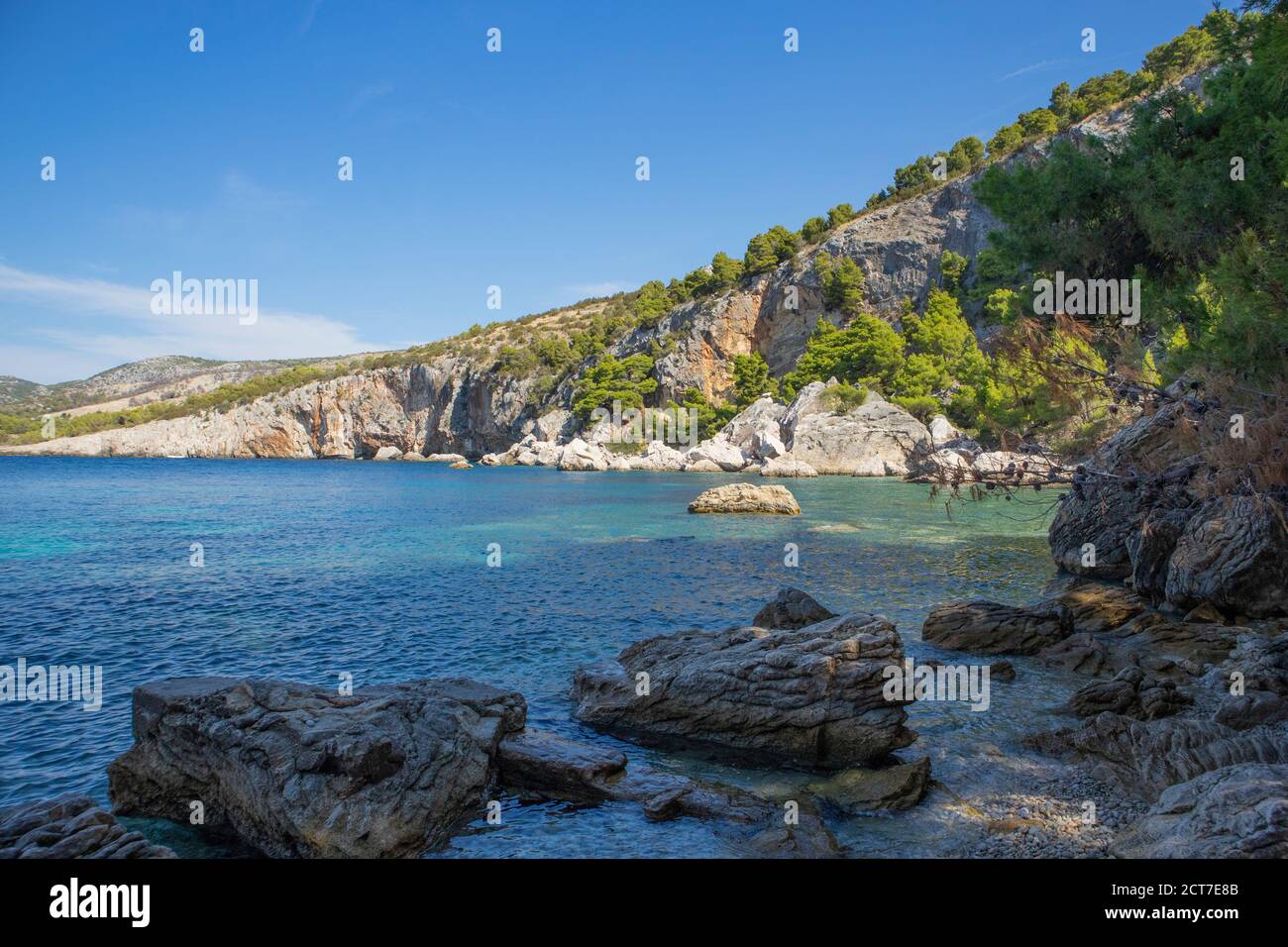 Magnífico paisaje natural de la popular playa de 'Zarace' en la isla de Hvar, destino turístico popular en el mar Adriático, rodeado de escarpada, rocosa cl Foto de stock