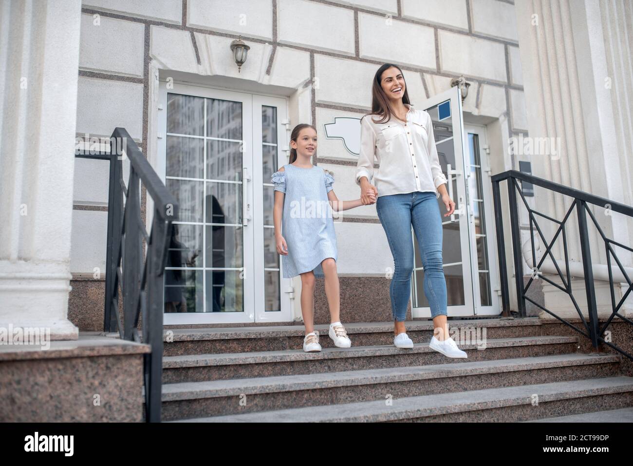 Mujer e hija en la entrada de su casa fotografías e imágenes de alta