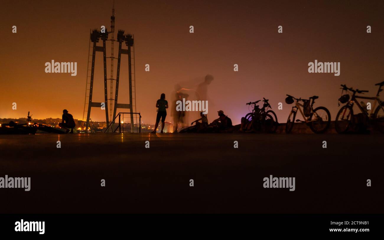 Ciclismo aventura al aire libre. Bicicletas con gente paisaje nocturno. Deportes al aire libre Foto de stock