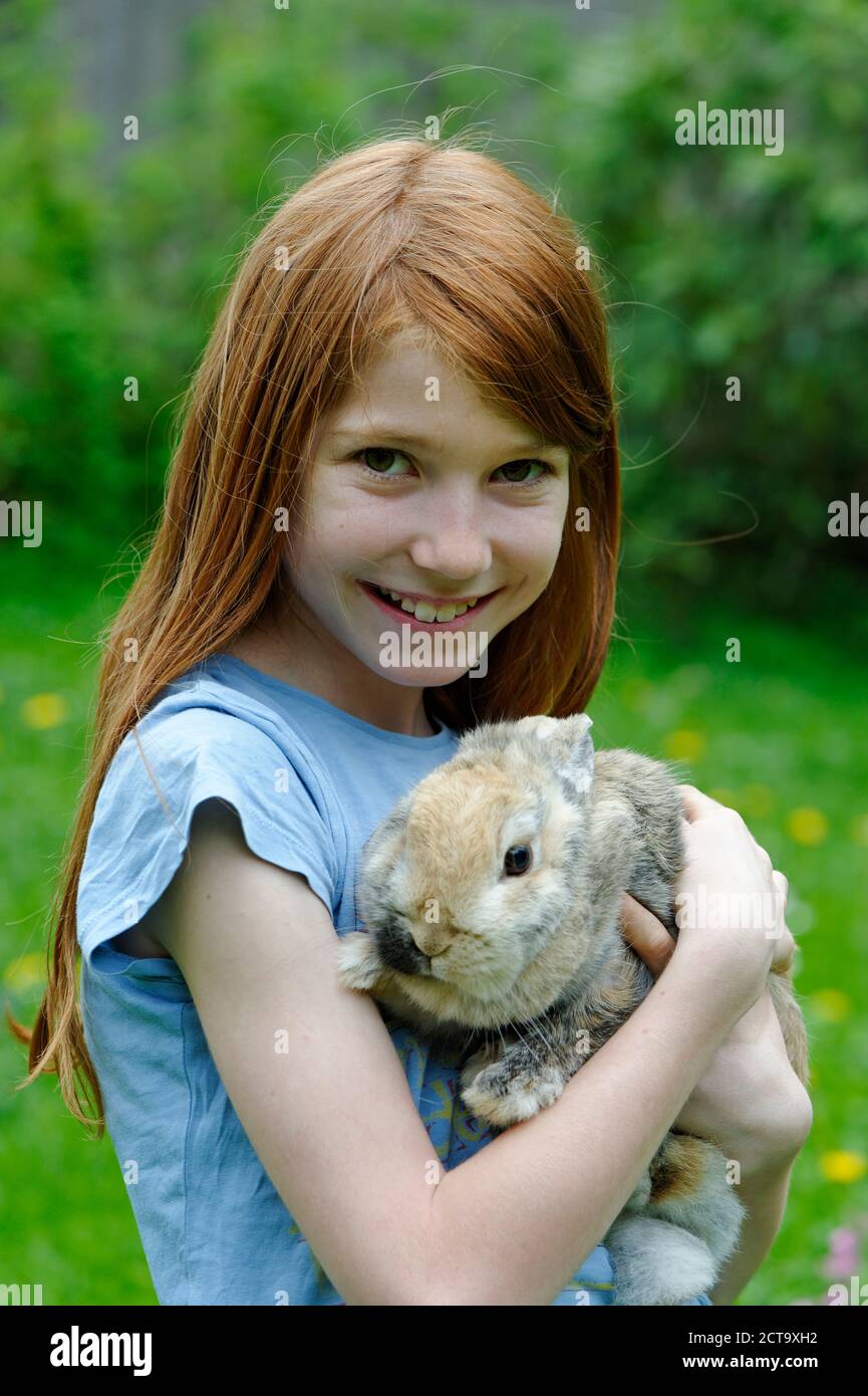 Chica sujetando un conejo enano Foto de stock