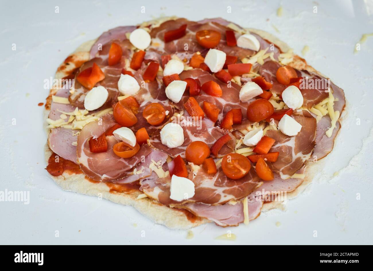 Elaboración de pizza casera italiana en horno de ladrillo chimenea. Hacer  pizza y añadir diferentes ingredientes antes de hornearla en la chimenea  exterior. RAW Fotografía de stock - Alamy