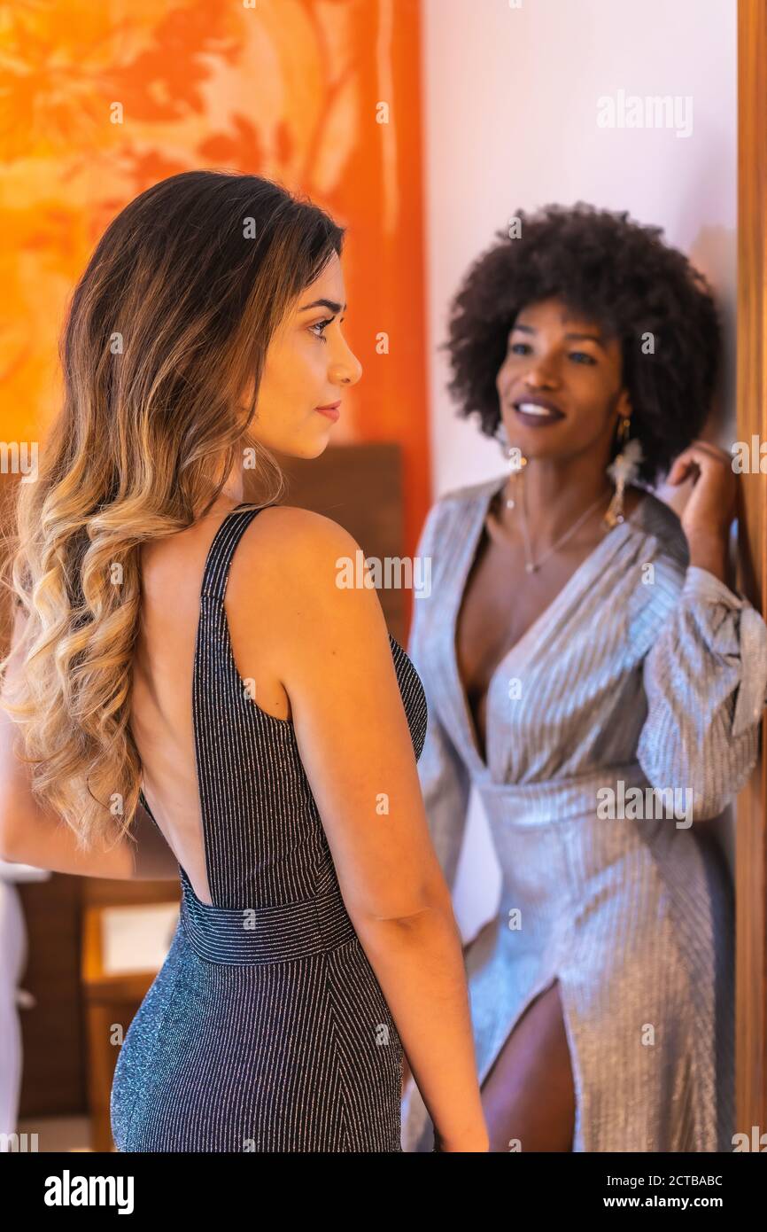 Disparo vertical de mujeres hermosas hispanas y caucásicas posando con  elegantes vestidos Fotografía de stock - Alamy