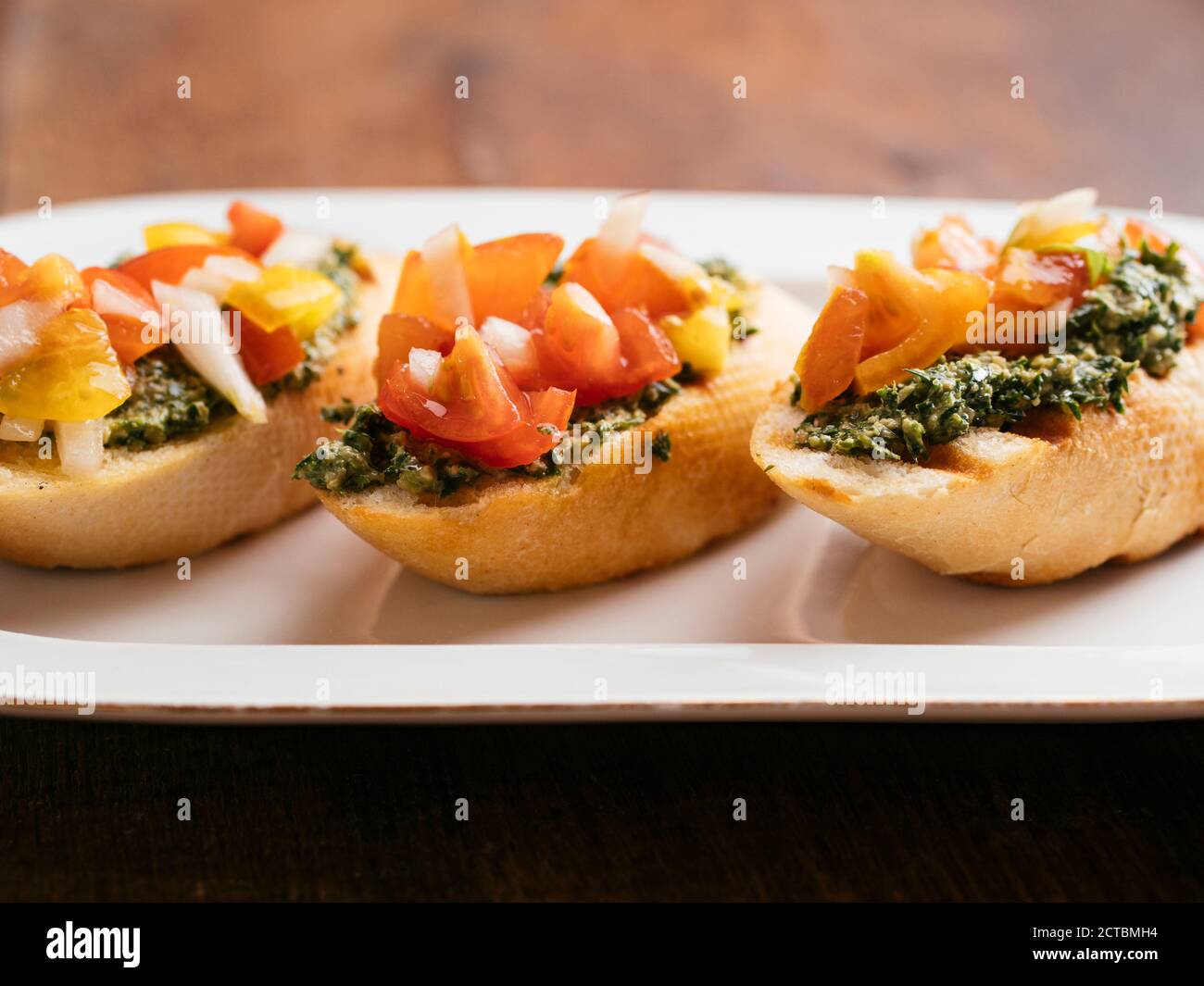 Bruschetta tradicional de tomate italiano con pesto casero de zanahoria vegetariana. Foto de stock