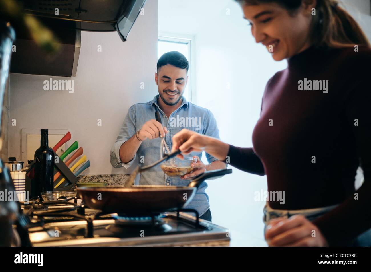 Marido y mujer cocinando juntos una tortilla para el desayuno Foto de stock