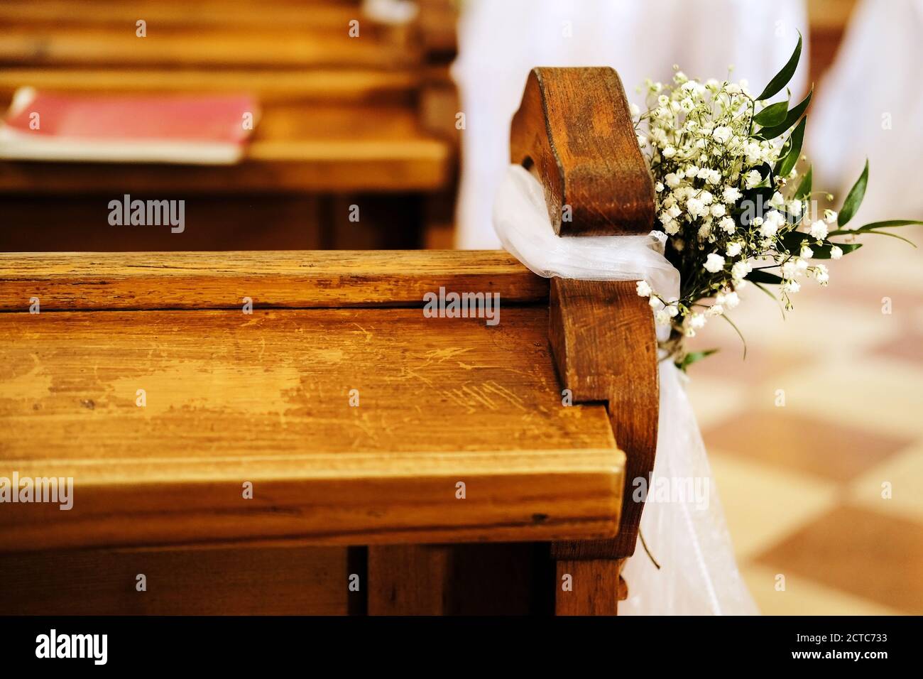 bancos en la iglesia decorada con flores blancas y tela para una boda Foto de stock