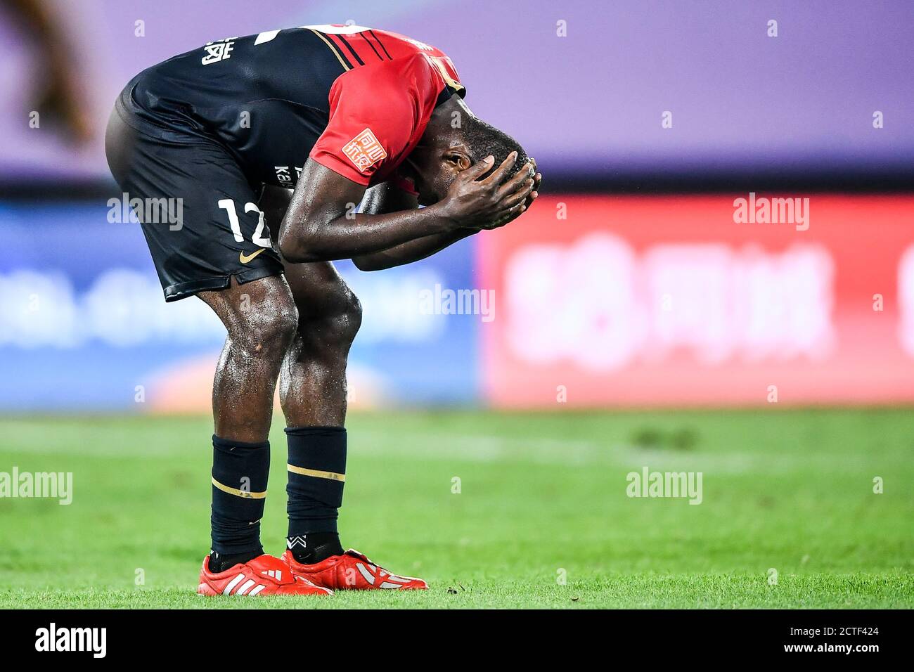 El futbolista camerunés John Mary de Shenzhen F.C. lamenta durante el partido de la cuarta ronda de 2020 de la Super Liga China (CSL) contra Henan Jianye F Foto de stock