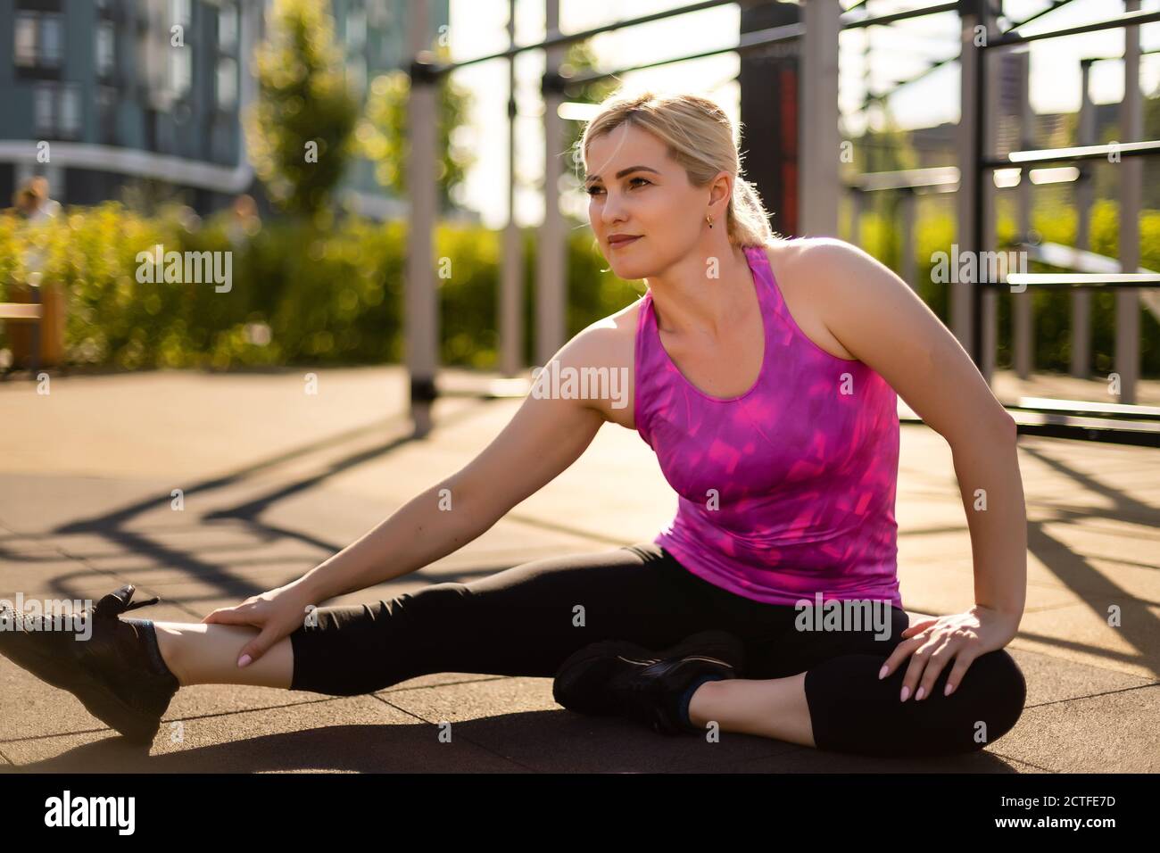 Deporte mujer de fitness de moda ropa deportiva hacer yoga ejercicio de  fitness en la calle, deportes al aire libre, estilo urbano Fotografía de  stock - Alamy