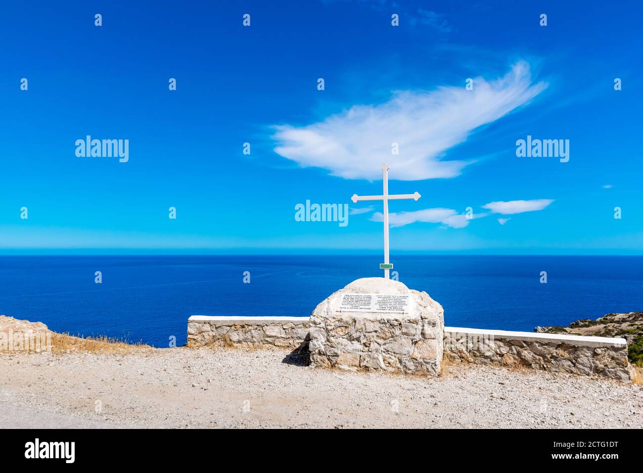 Cruz blanca con vistas al mar Egeo, mirador en la isla de Karpathos, Grecia Foto de stock
