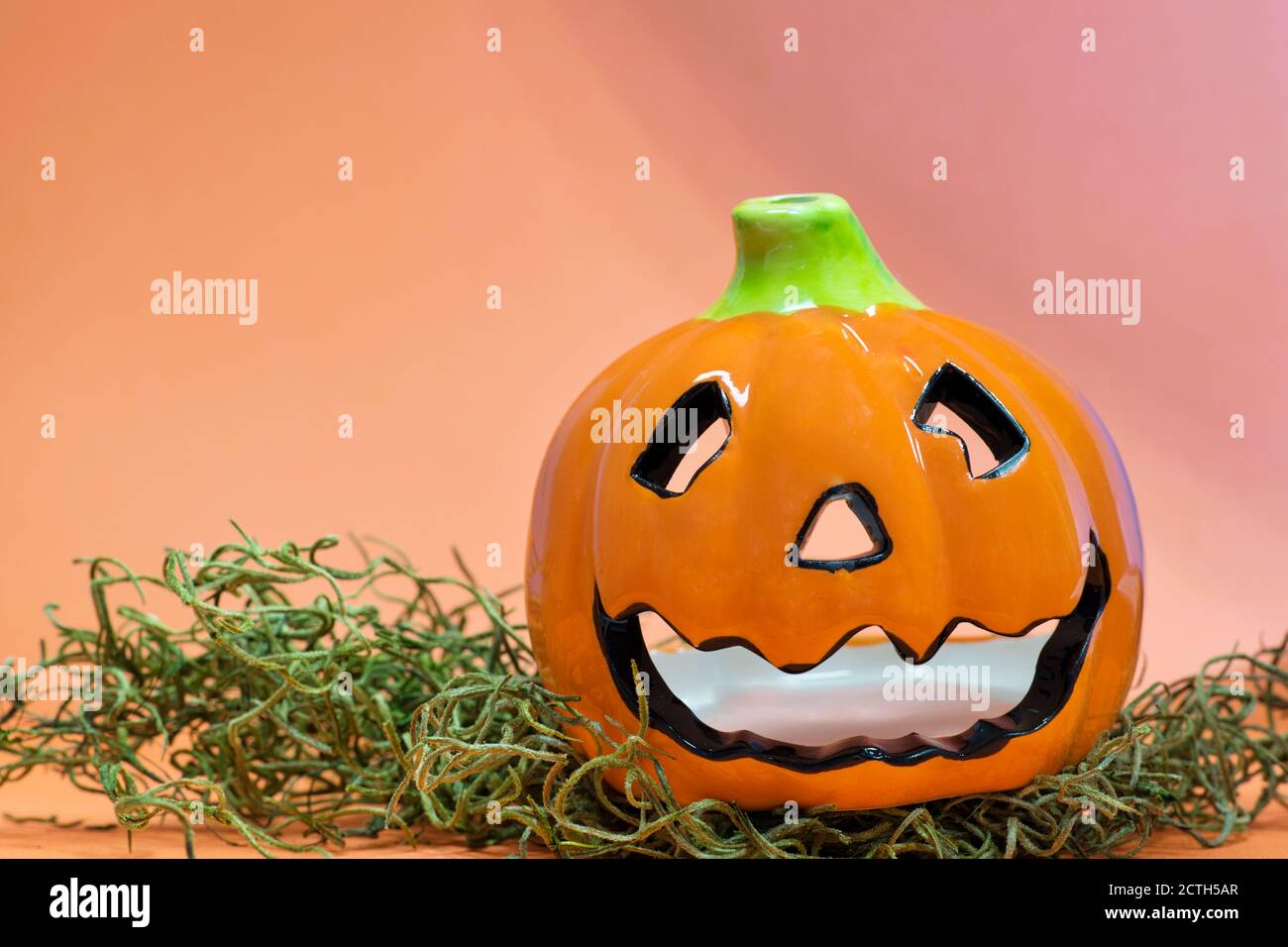Halloween calabaza té decoración ligera en una cama de hierba con fondo de  color naranja y espacio de copia Fotografía de stock - Alamy