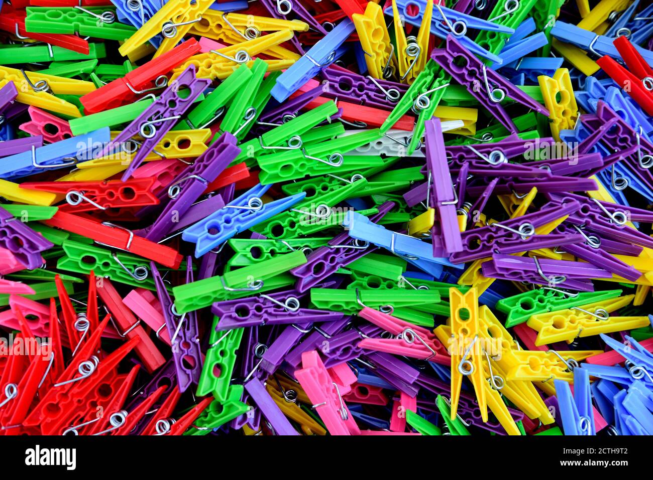Surtido multicolor de alfileres de plástico de colores brillantes esparcidos en la ropa un montón de stock - Alamy