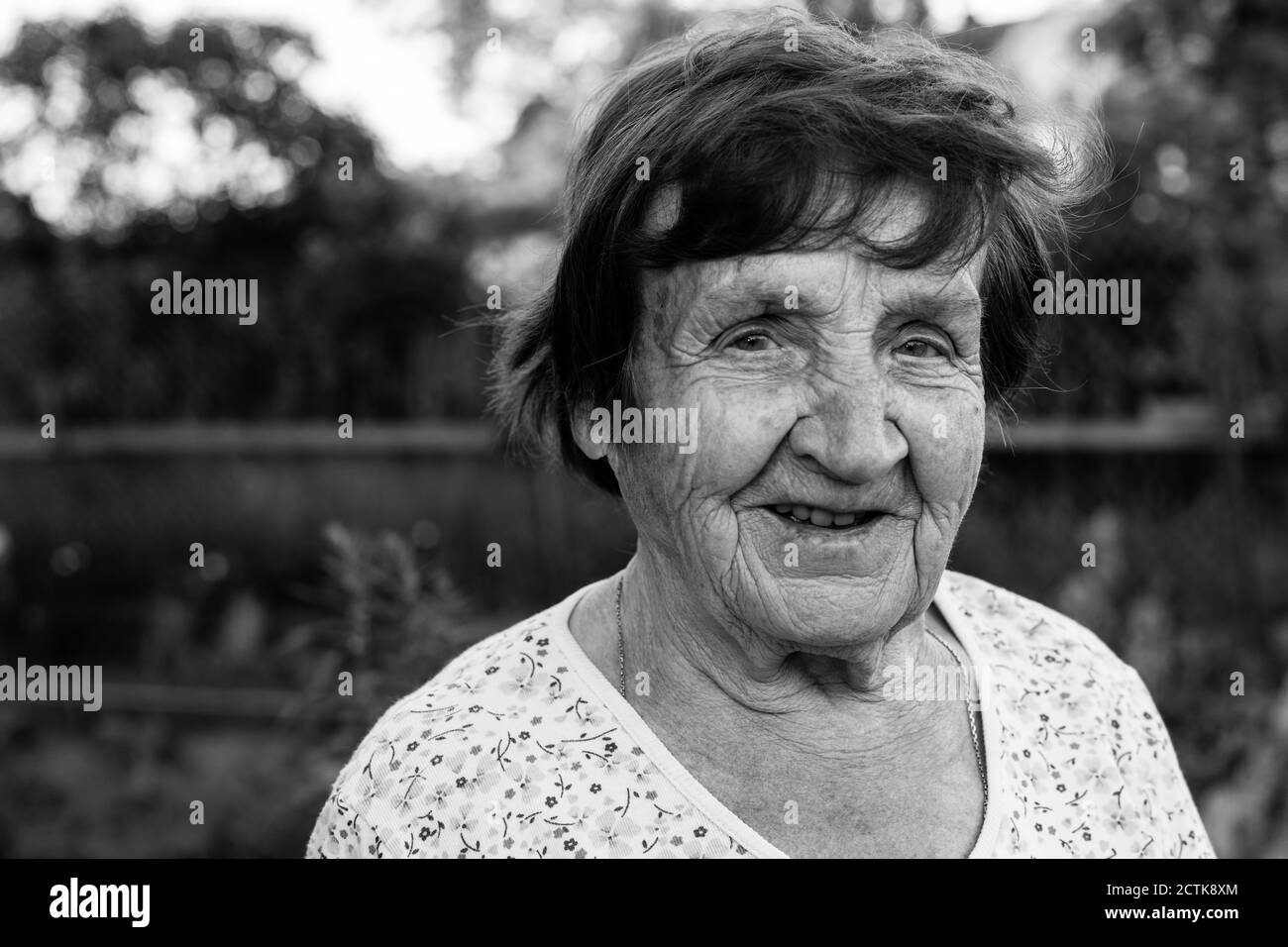 Primer plano retrato de una anciana, al aire libre. Fotografía en blanco y negro. Foto de stock