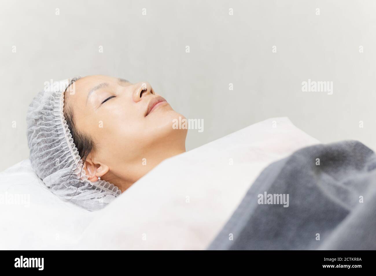 Hermosa mujer con la piel sana limpia relajante tumbado en el salón de spa. Foto de stock