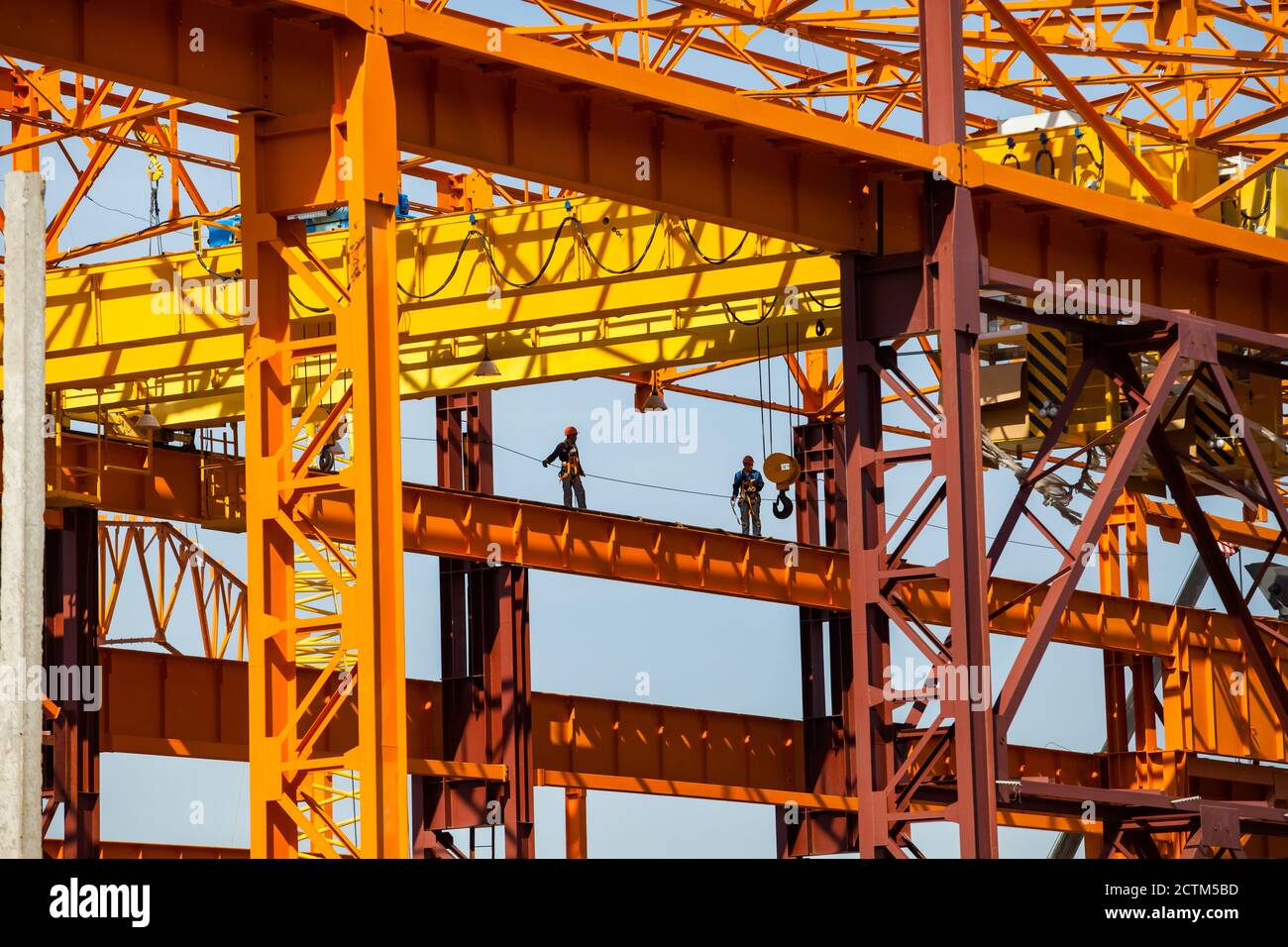 Kostanay/Kazakhstan - Mayo 14 2012: Construcción de una nueva estructura de metal anaranjado. Dos trabajadores de gran altitud (escaladores industriales) con un Foto de stock