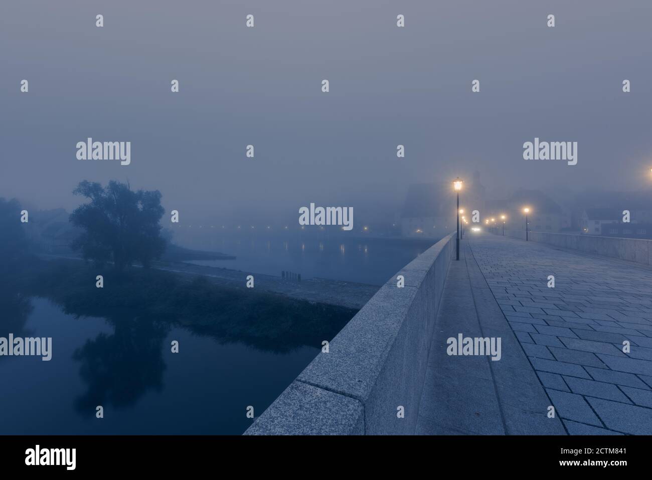 Steinerne Brücke en Regensburg am Morgen im Herbst mit Nebel Foto de stock