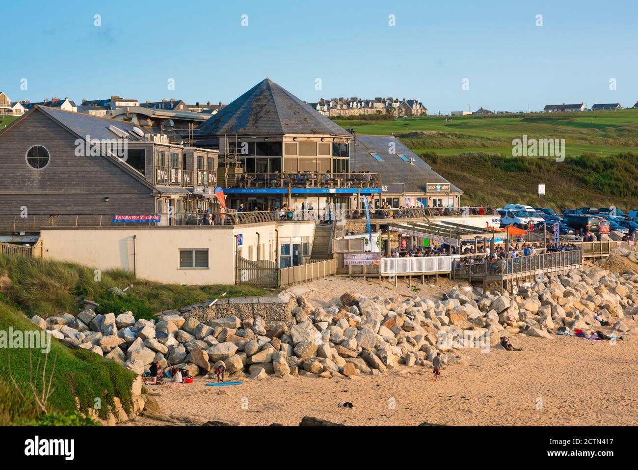 Bar Fistral Beach, vista en una noche de verano de la gente que se relaja en la terraza frente al mar del restaurante Fistral Stable, Fistral Beach, Newquay, Reino Unido Foto de stock