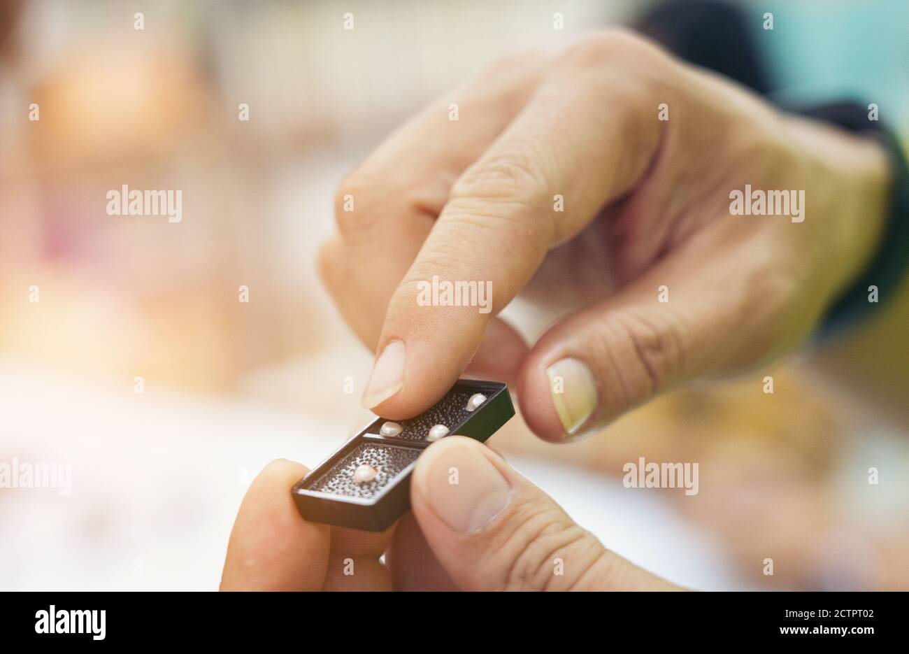 primer plano mano toque dominó abultamiento juego estrategia de mano para ciegos Foto de stock