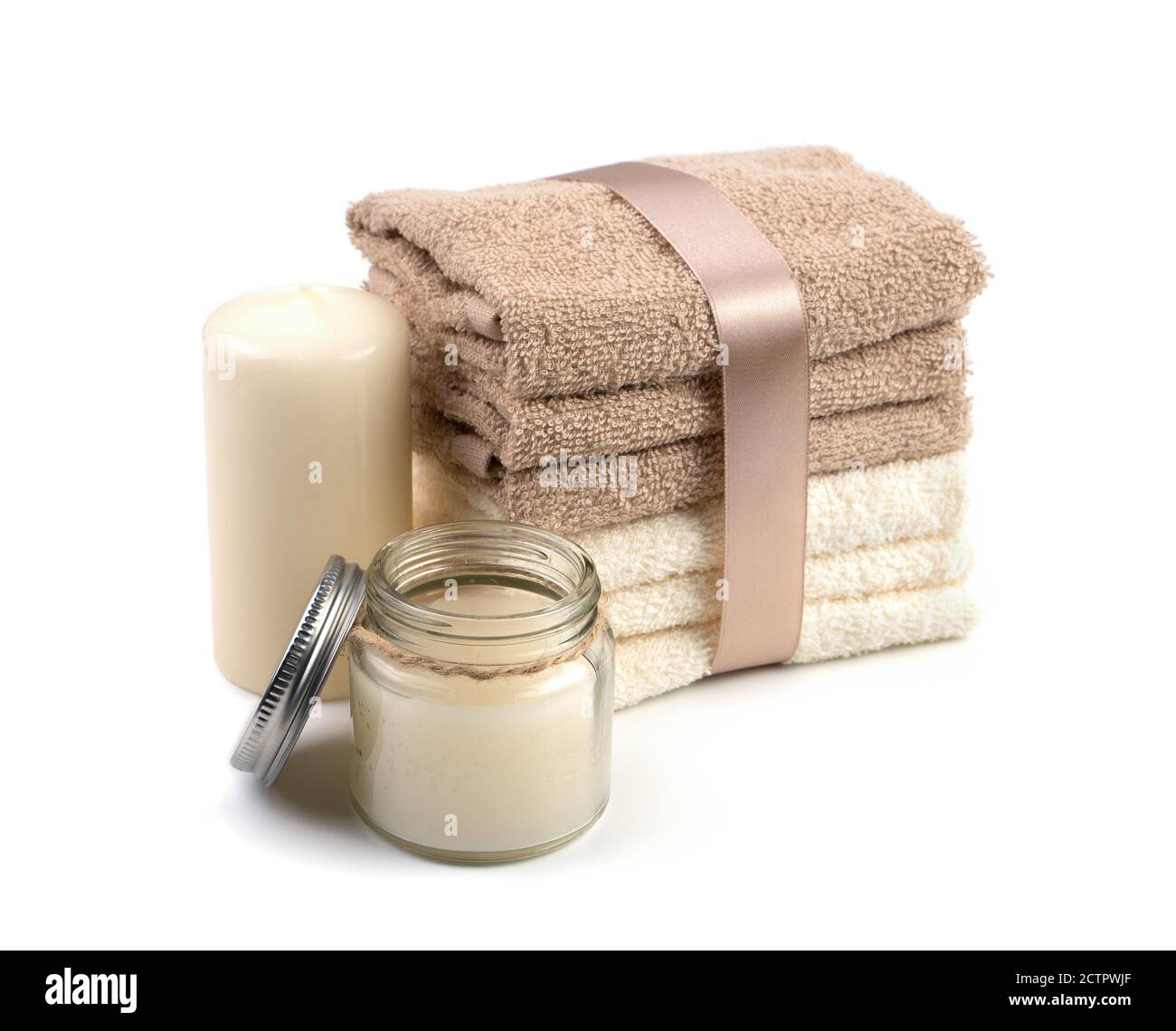 Un juego de toallas de baño de felpa beige una toalla cuelga de un  travesaño en el spa