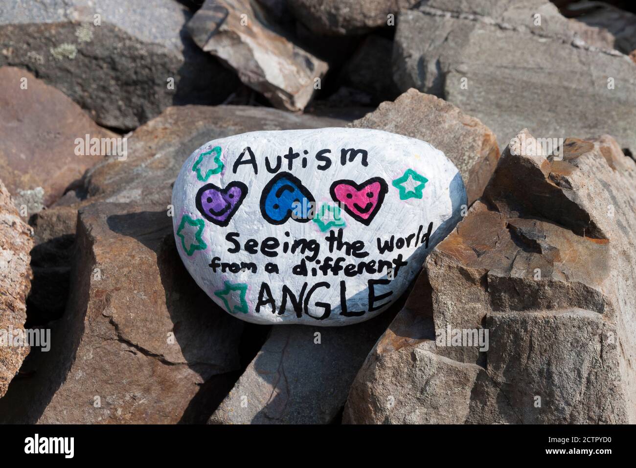 Pintó roca con un mensaje inspirador sobre el Autismo. Foto de stock