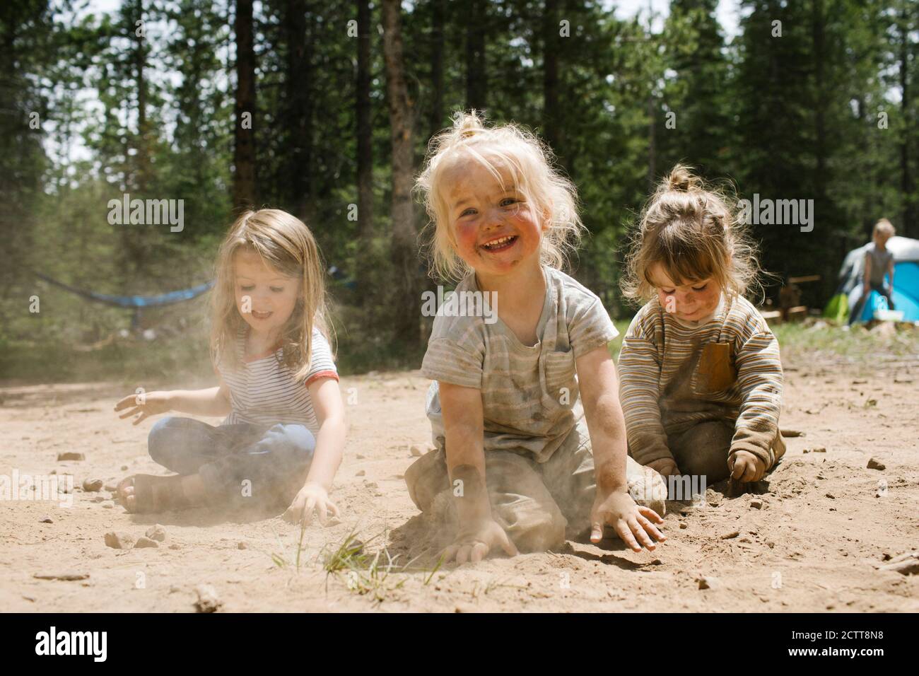 Tres chicas sonrientes (2-3, 4-5) jugando en la arena en el camping, Wasatch-Cache National Forest Foto de stock