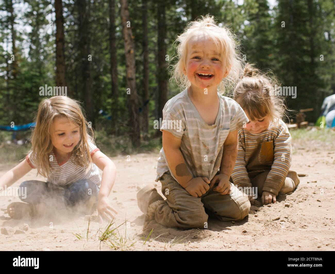 Tres chicas sonrientes (2-3, 4-5) jugando en la arena en el camping, Wasatch-Cache National Forest Foto de stock