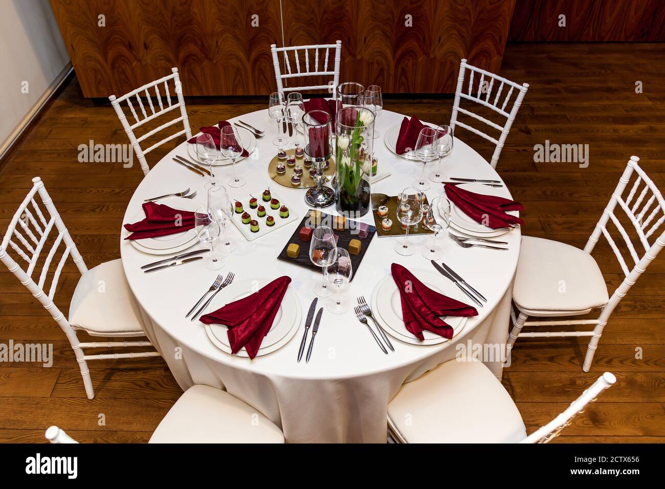 Mesa redonda con mantel blanco y servilletas rojas, juego de cubiertos con  aperitivos para el banquete. Catering, mesas de servidor para el bonquet  Fotografía de stock - Alamy