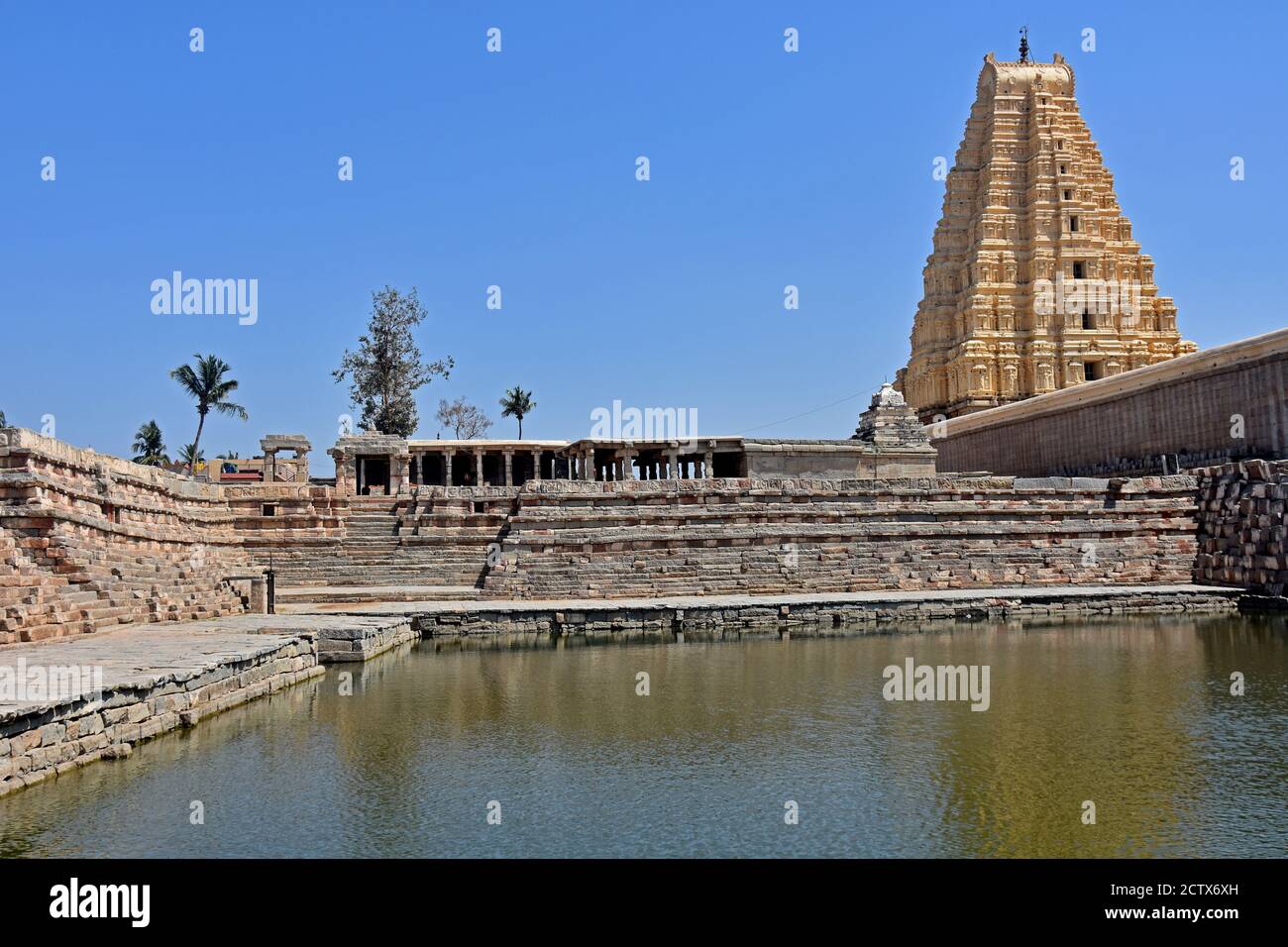 Vista del templo de Virupaksha desde la parte trasera con estanque, situado en las ruinas de la antigua ciudad de Vijayanagar en Hampi, India. Foto de stock