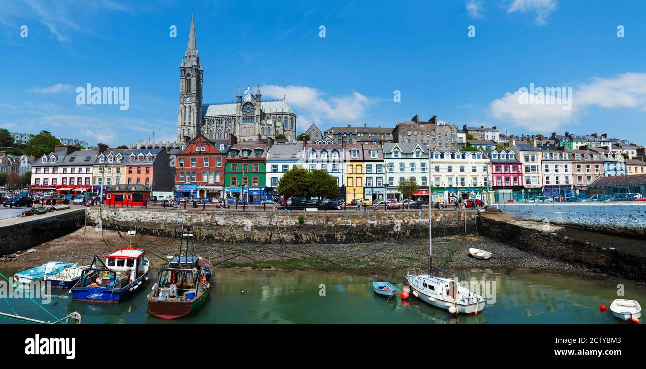 Barcos de pesca en un puerto con una catedral en el fondo, la Catedral de San Colman, Cobh, Condado de Cork, República de Irlanda Foto de stock