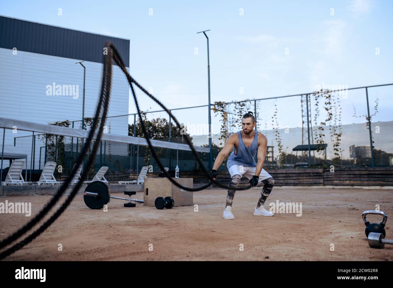 Hombre atlético con cuerdas, entrenamiento en la calle, crossfit Foto de stock
