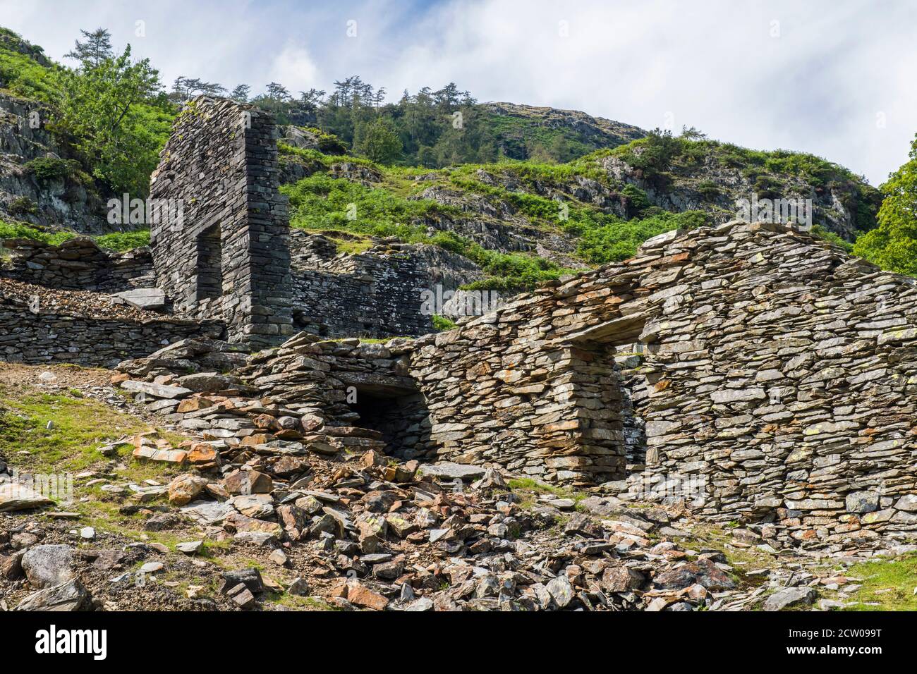Los restos en ruinas de edificios a mitad de camino en la orilla del valle de Tilberthwaite en el Distrito de los Lagos. Estos bien pueden haber sido edificios de canteras. Foto de stock