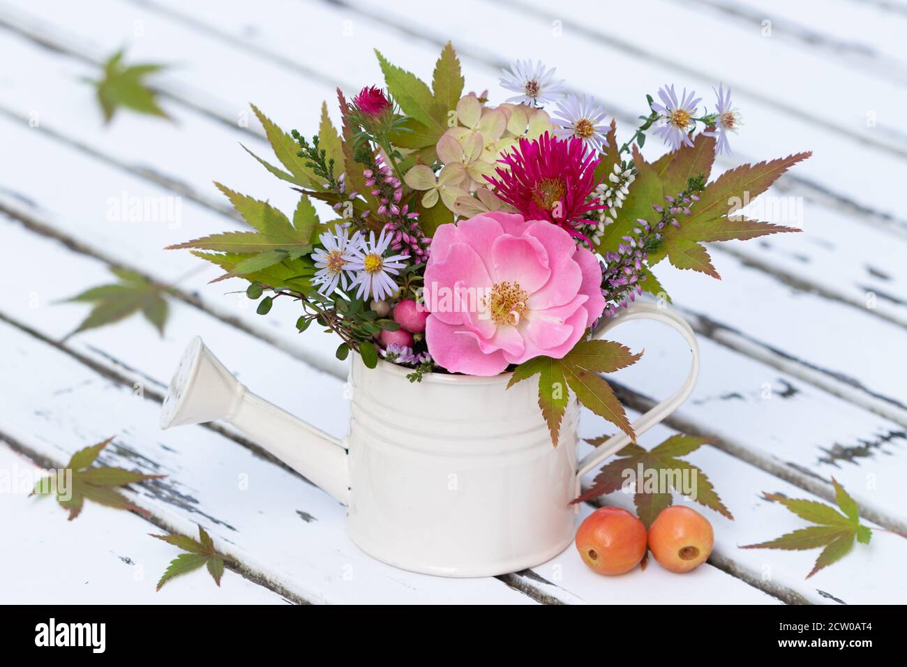 ramo de rosa rosa, flores de montaña y flores de hortensias en regadera decorativa Foto de stock