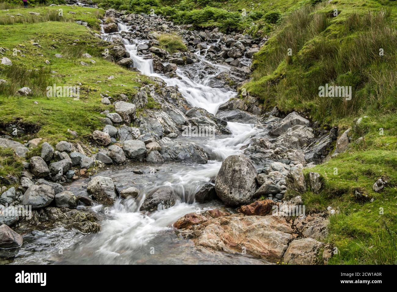 Uno de los varios arroyos que caen por la orilla de la calle Kirkstone Pass. Cerca de la carretera como se baja a Brotherswater y Ullswater. Foto de stock