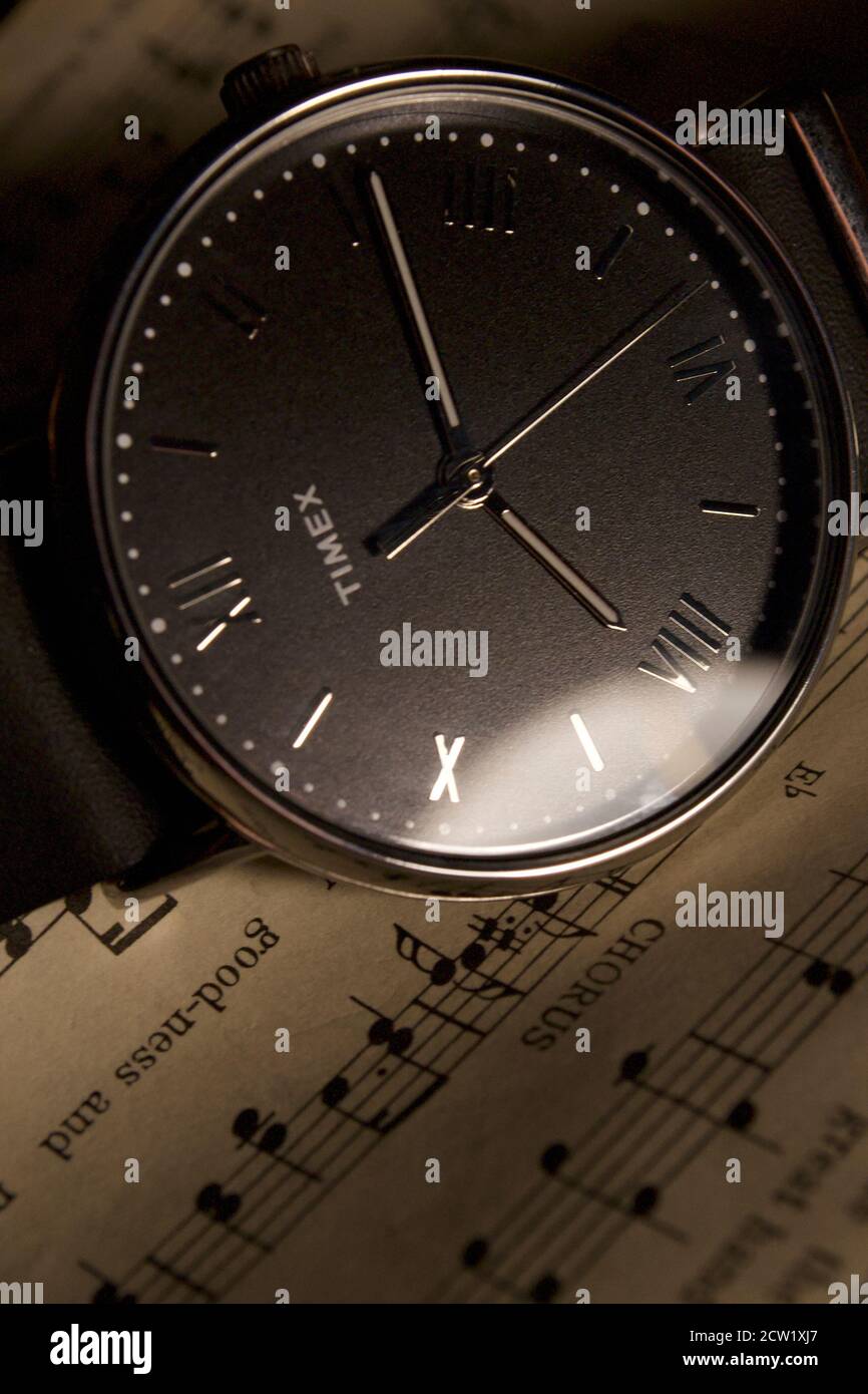 Reloj de pulsera analógico Timex tendido en la partitura. Correa de cuero  negro con números romanos plateados Fotografía de stock - Alamy