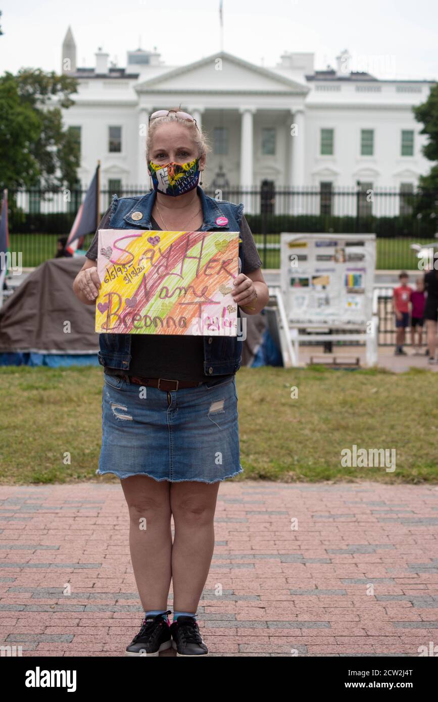La activista femenina tiene un signo contra el racismo frente a la Casa Blanca. Foto de stock