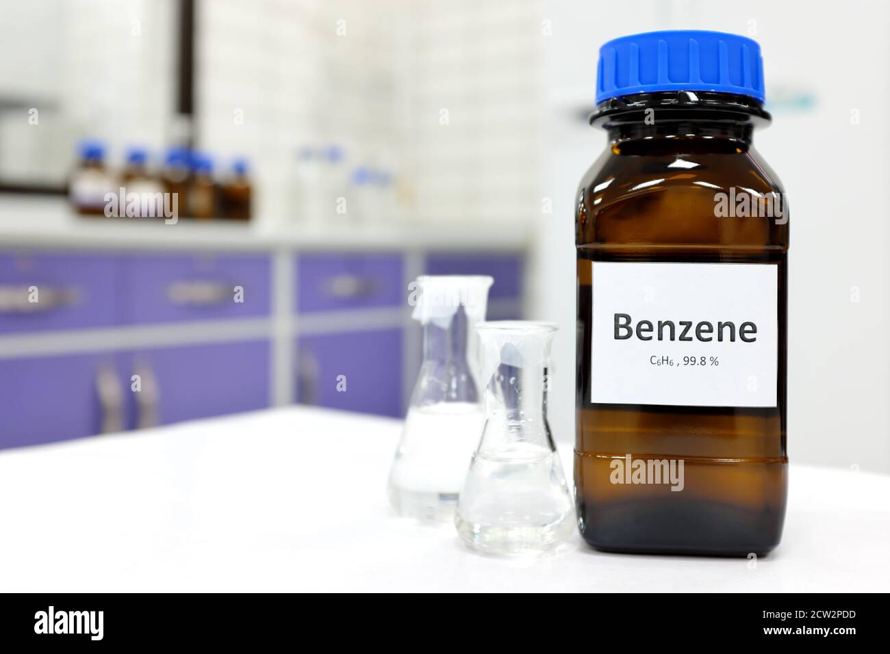 Enfoque selectivo del compuesto químico líquido benceno en botella de vidrio oscuro dentro de un laboratorio de química con espacio de copia. Hidrocarburo aromático utilizado en p Foto de stock