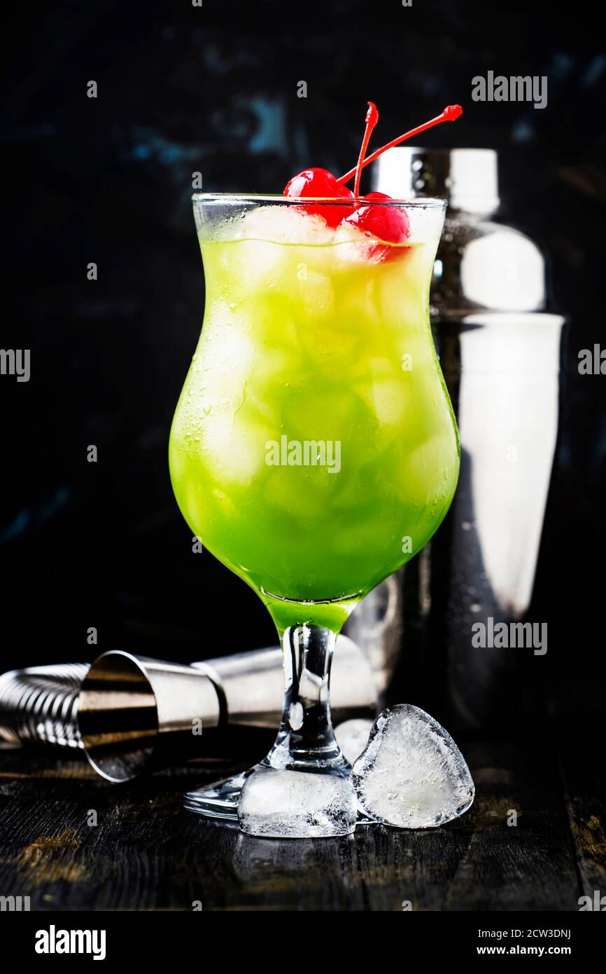Cóctel verde con cerezas de maraschino en un cristal de huracán, fondo  oscuro, enfoque selectivo Fotografía de stock - Alamy