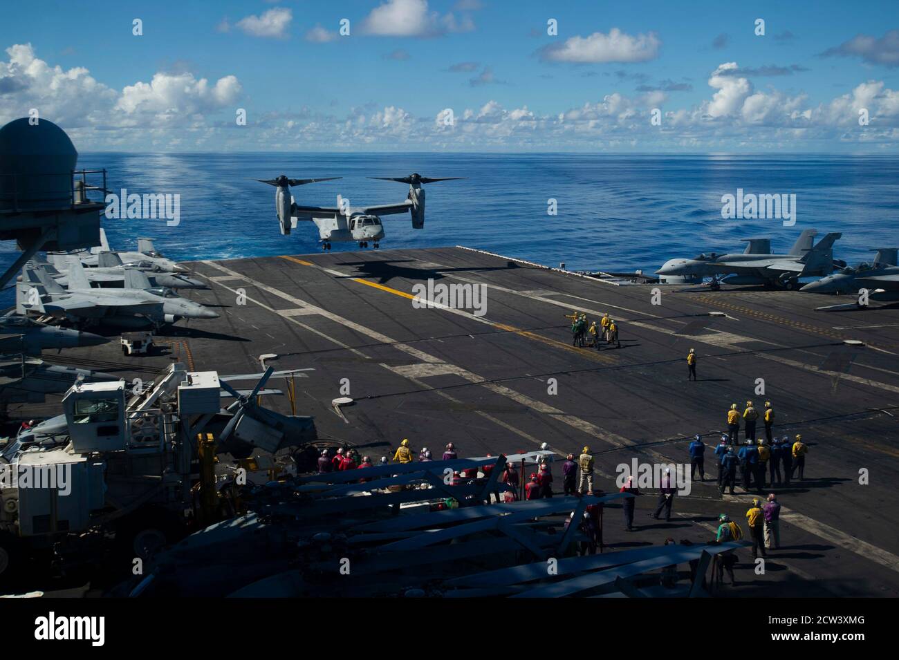 Un MV-22 Osprey, asignado al escuadrón de Tiltrotor Medio Marino (VMM) 262, se prepara para aterrizar en la cubierta de vuelo del portaaviones USS Ronald Reagan (CVN 76), durante las operaciones integradas de la Fuerza de ataque Expedicionario con el USS America (LHA 6). El Ronald Reagan Carrier Strike Group y el America Expeditionary Strike Group con el 31º MEU embarcado están desplegados hacia adelante en el área de operaciones de la 7º flota de EE.UU. En apoyo de la seguridad y la estabilidad en el Indo-Pacífico. (EE.UU Foto de la Marina por el Especialista en Comunicación de masas Seaman Apprentice Oswald Felix Jr.) Foto de stock