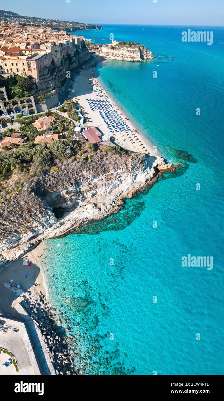 Vista aérea de una playa con sombrillas y bañistas. Casas en la roca.  Promontorio del Santuario de Santa Maria dell'Isola, Tropea, Calabria,  Italia Fotografía de stock - Alamy