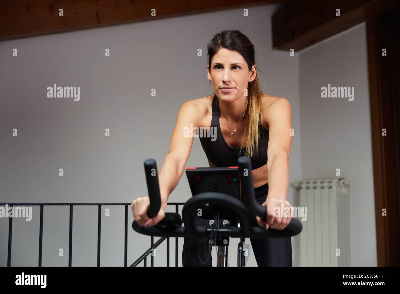 Piernas de mujer entrenando en bicicleta elíptica en la sala de estar en  casa Fotografía de stock - Alamy