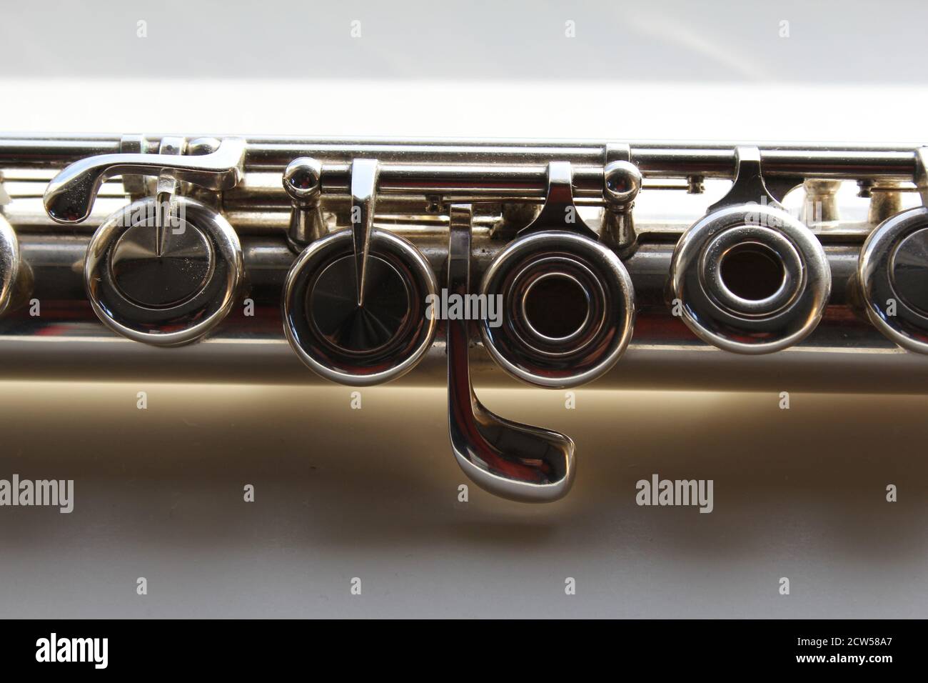 la parte media simétrica de un hermoso concierto transversal de plata flauta con válvulas brillantes Foto de stock