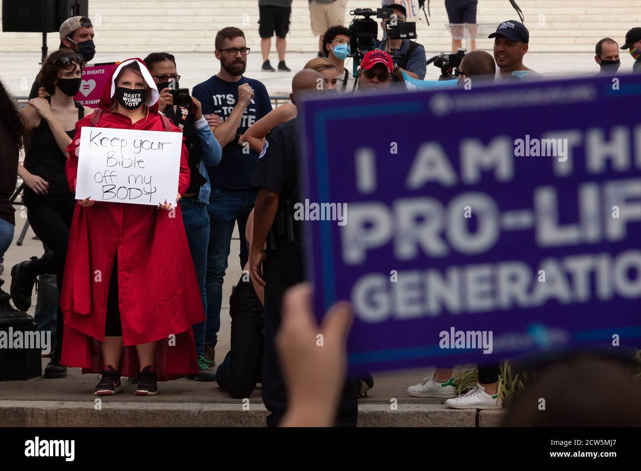 Washington, DC, EE.UU., 27 de septiembre de 2020. En la foto: Un  manifestante vestido como una sierva se enfrenta con un contraprotester  anti-aborto en la reunión de no confirmación hasta la Inauguración