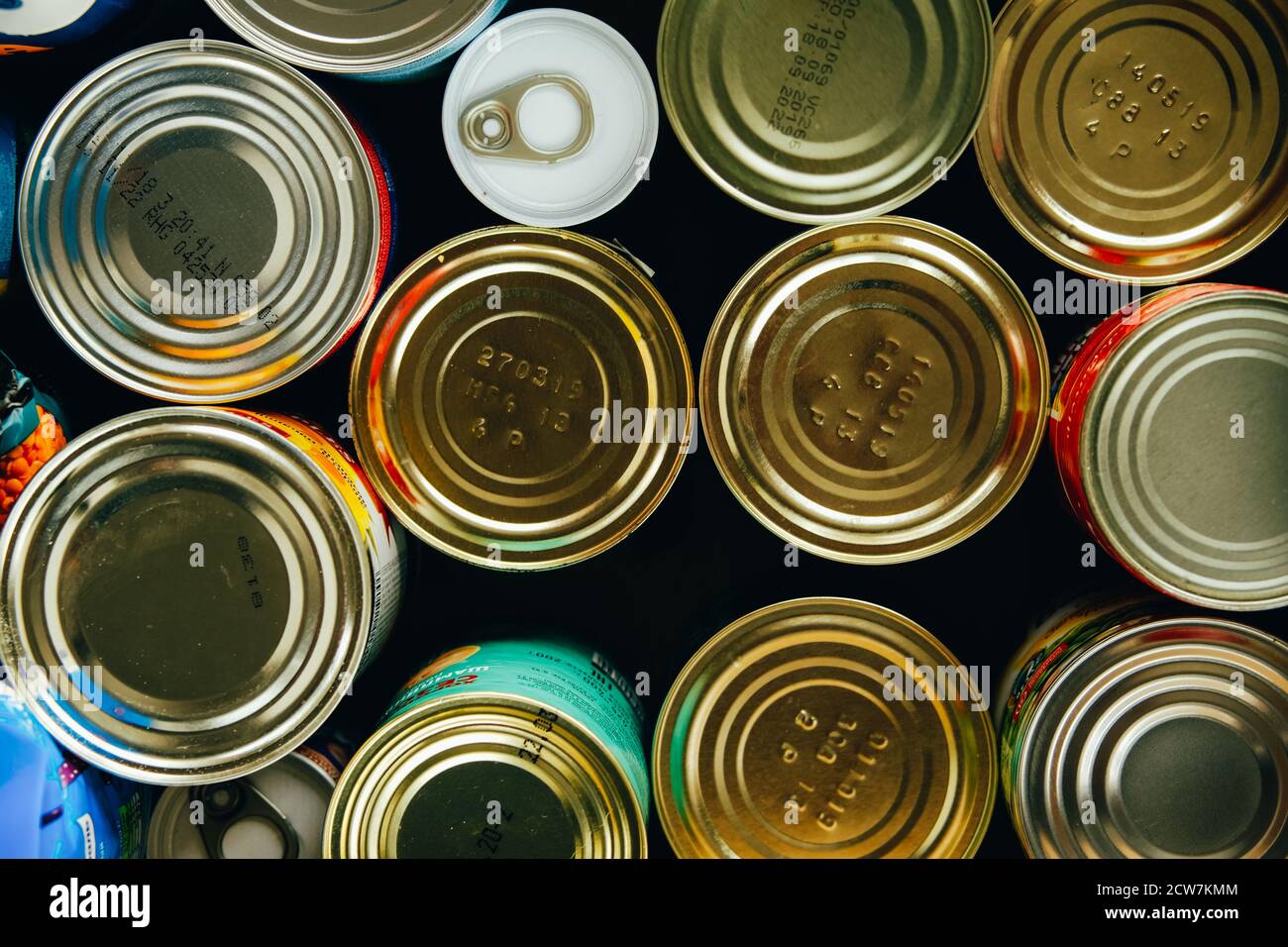 Varios alimentos enlatados en latas de metal, vista superior, almacenamiento de alimentos no perecederos o donaciones Foto de stock