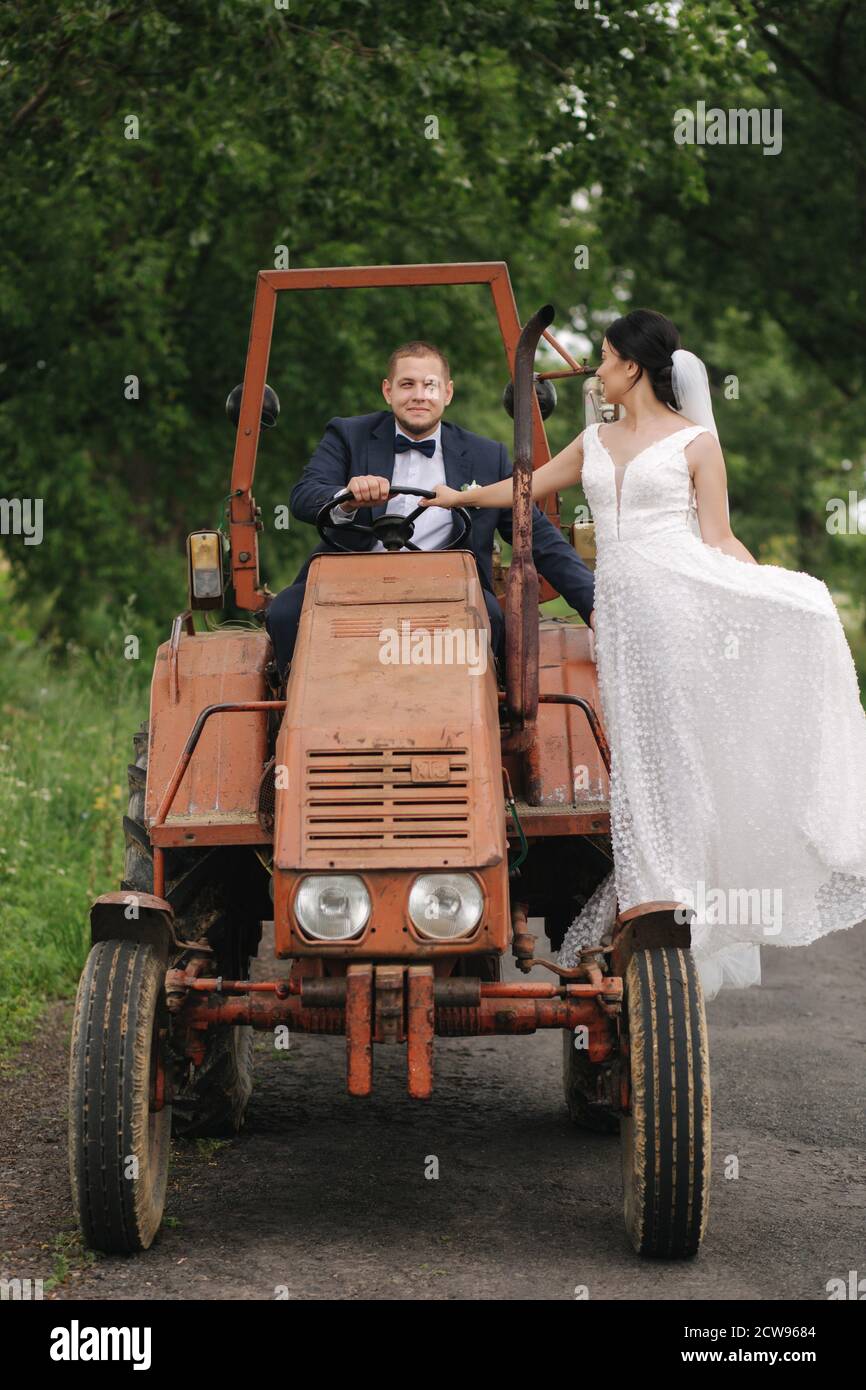 Pareja de boda en el tractor. Novio y novia beso Fotografía de stock - Alamy