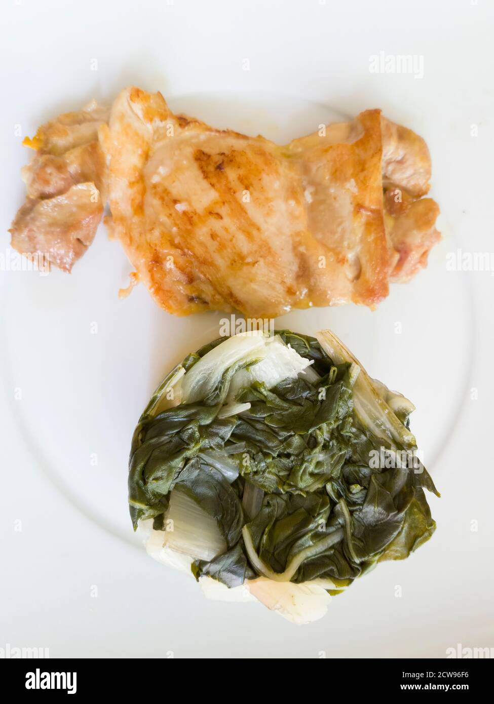 Pollo a la parrilla con garnished con acelga. Una comida ideal para seguir una dieta saludable y equilibrada Foto de stock