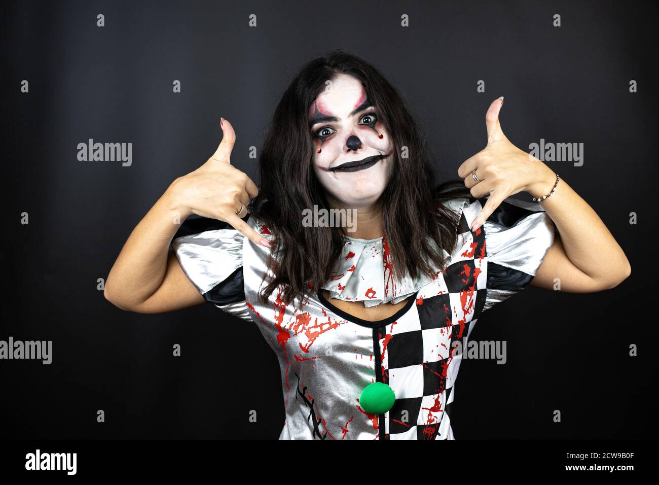 mujer en un traje de halloween payaso sobre fondo negro aislado gritando  con una expresión loca haciendo el símbolo de rock con las manos hacia  arriba Fotografía de stock - Alamy
