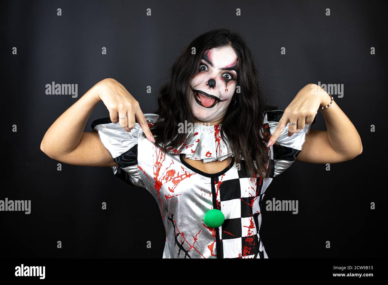 Metáfora segmento Para llevar mujer en un disfraz de halloween payaso sobre fondo negro aislado que mira  confidente con sonrisa en la cara, apuntando con los dedos orgulloso y  feliz Fotografía de stock - Alamy