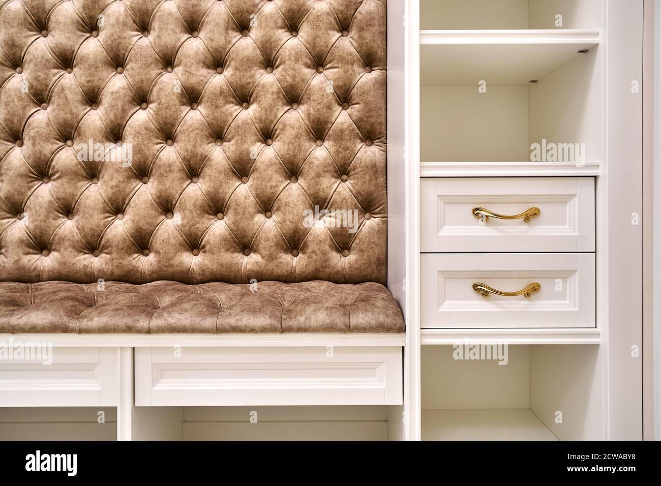 armario blanco clásico con asientos y estantes en un pasillo luminoso y  contemporáneo. Muebles clásicos. Banco del armario del acoplador del carro  Fotografía de stock - Alamy