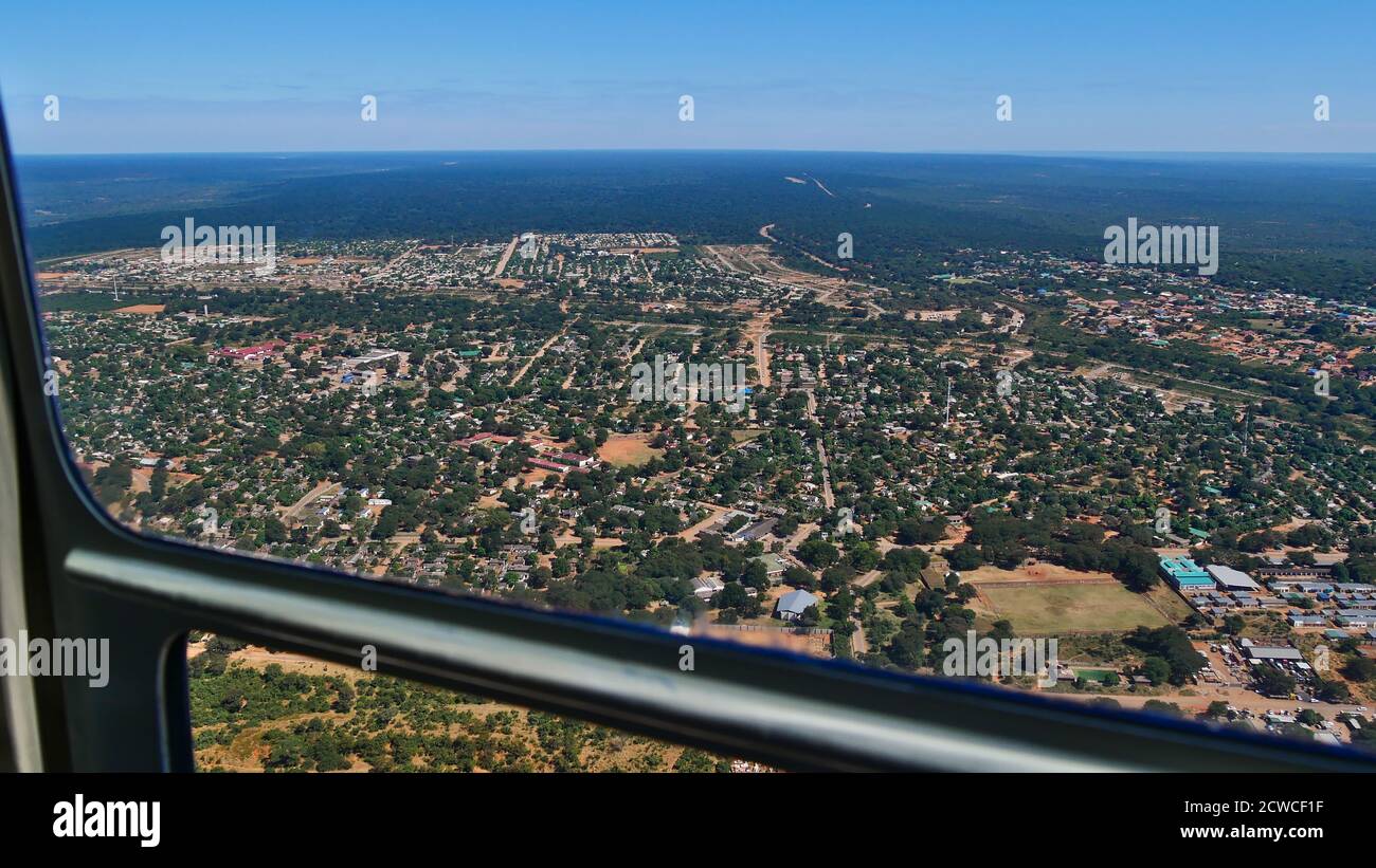 Vista aérea desde helicóptero sobre la famosa ciudad de Victoria Falls y tierra de arbustos en la frontera de Zimbabwe y Zambia en un día soleado con cielo azul. Foto de stock
